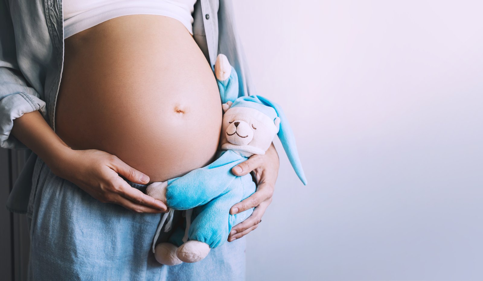 Schwangere hält ein Kuscheltier